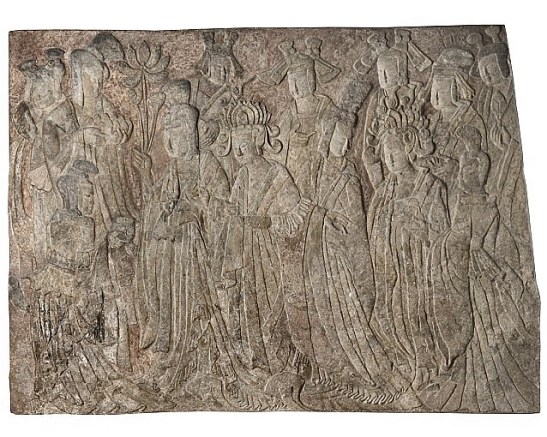 A photo of a dark limestone, shallow carved relief sculpture with traces of color. A group of figures, men and women in ceremonial and royal dress, face right and process across the block of stone. 