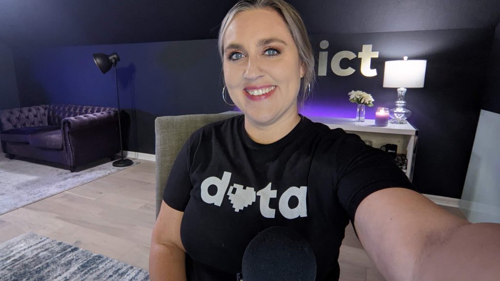 Ann K. Emery from Depict Data Studio is smiling at her desk in her home office.